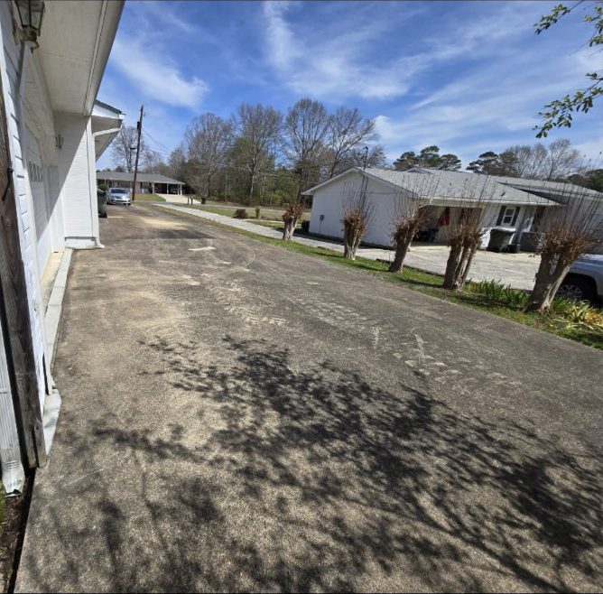 Driveway darkened with heavy dirt and algae buildup before pressure washing
